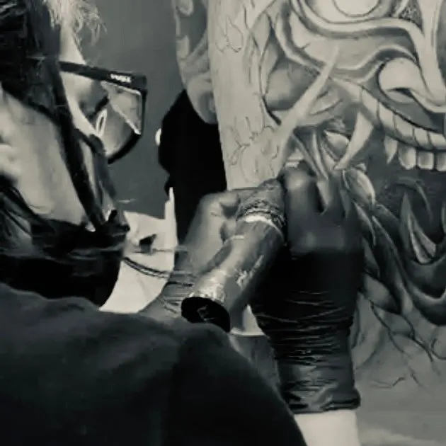 Evelin al lavoro con la macchinetta su una maschera Hannya in black and grey