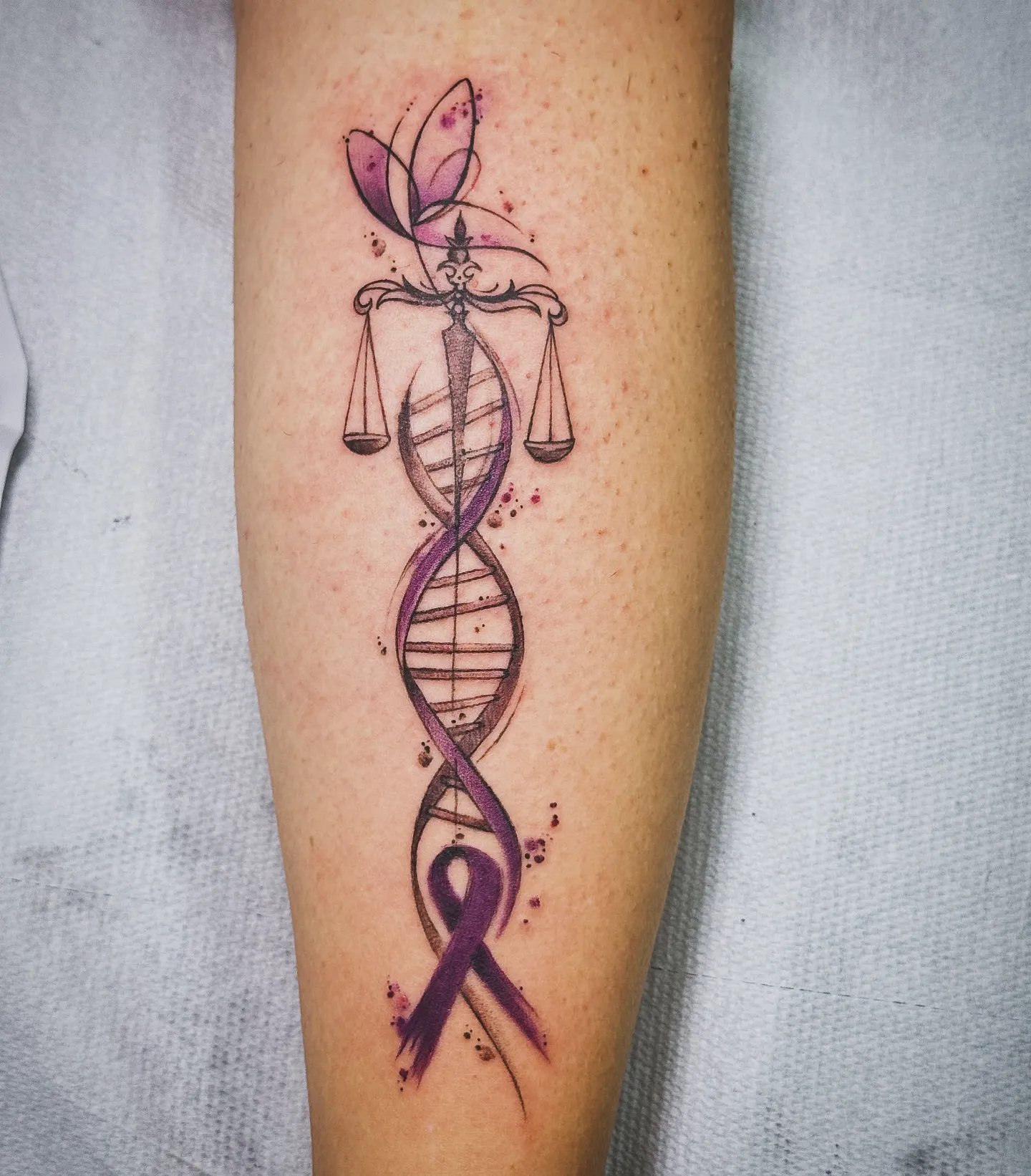 Tatuaggio watercolor con doppia elica del DNA e nastro viola